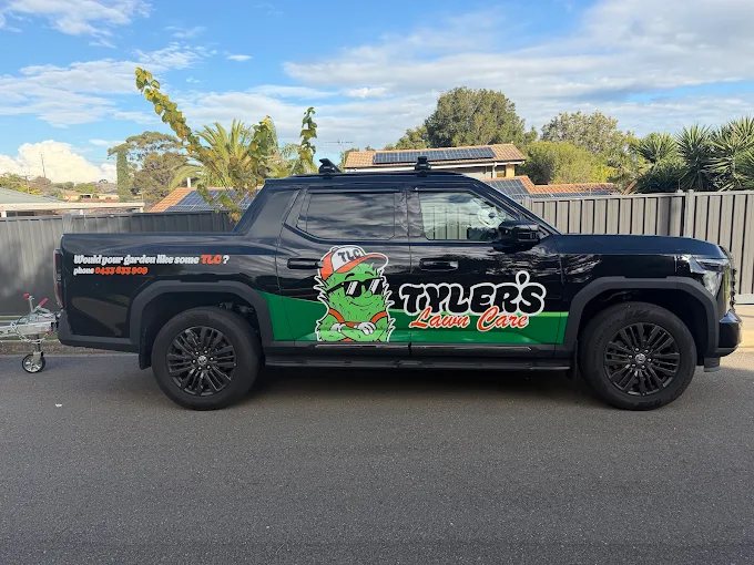 Tyler's Lawn Care branded black ute parked on the side of the road